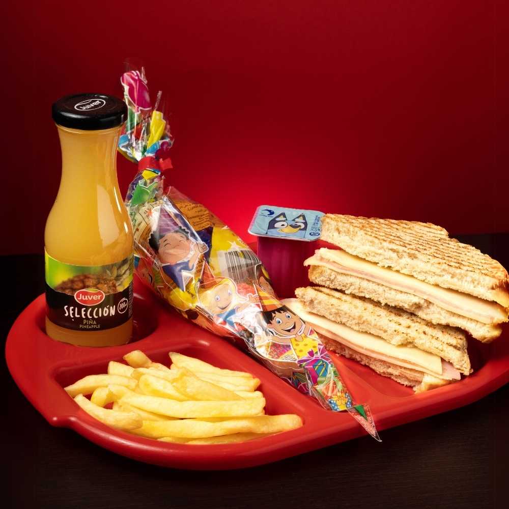 Menú infantil con sándwich de york y queso, patatas, bebida, postre y chuches